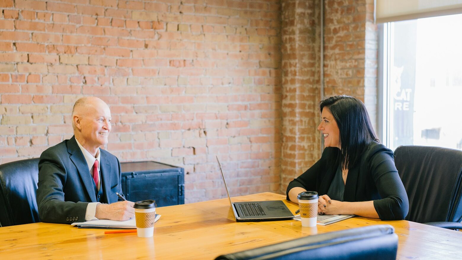 Two people talking across a table in an office